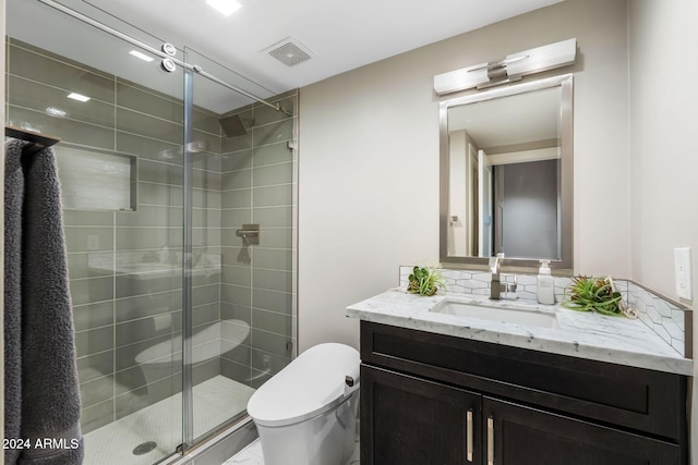 bathroom with an enclosed shower, vanity, and toilet