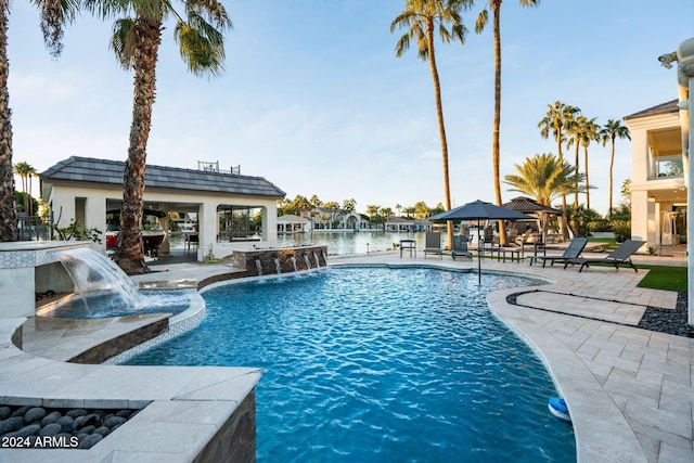 view of swimming pool featuring a gazebo, pool water feature, a water view, and a patio