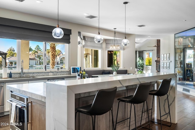 kitchen featuring dark hardwood / wood-style flooring, decorative light fixtures, and plenty of natural light