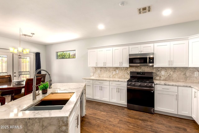 1492 E Westchester Dr, Chandler, AZ 85249 - kitchen featuring stainless steel appliances, a sink, a chandelier, white cabinets, and decorative backsplash