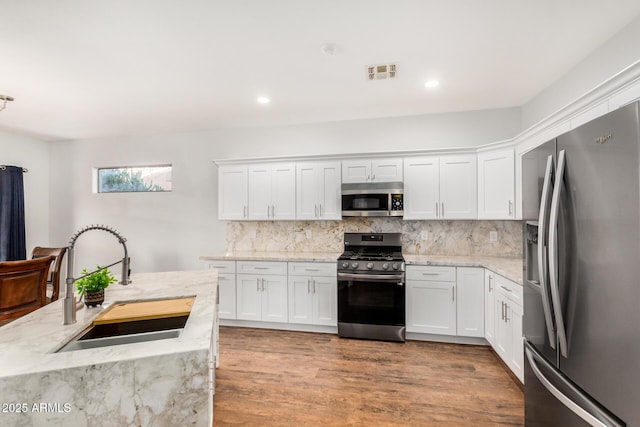 1492 E Westchester Dr, Chandler, AZ 85249 - kitchen featuring appliances with stainless steel finishes, a sink, white cabinets, backsplash, and recessed lighting