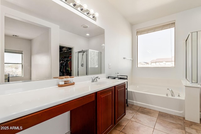 bathroom with vanity, tile patterned flooring, and plus walk in shower