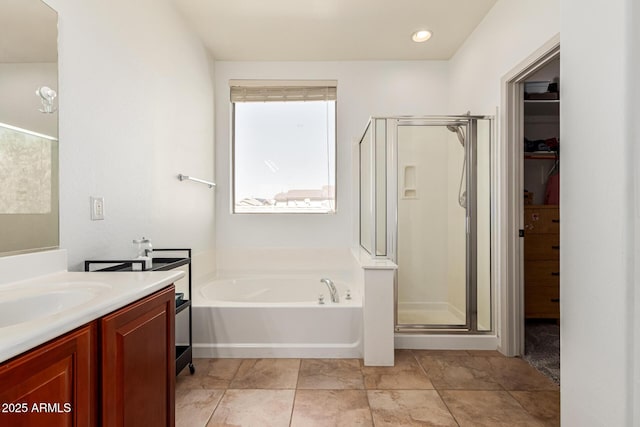 bathroom with vanity and shower with separate bathtub