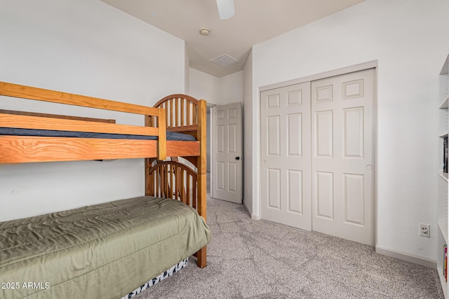 bedroom featuring light colored carpet, ceiling fan, and a closet