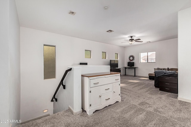 carpeted home office featuring ceiling fan