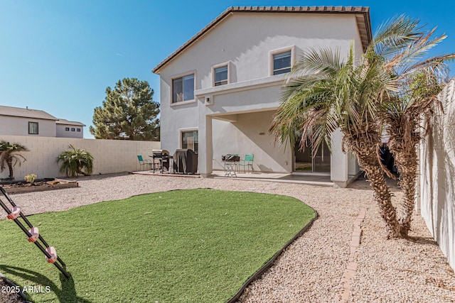 back of property featuring a yard and a patio