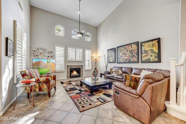 tiled living room featuring a fireplace and high vaulted ceiling