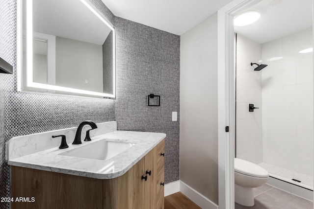 bathroom with a shower stall, toilet, vanity, and baseboards