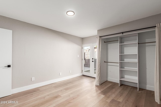 unfurnished bedroom featuring access to exterior, french doors, light wood-type flooring, and baseboards