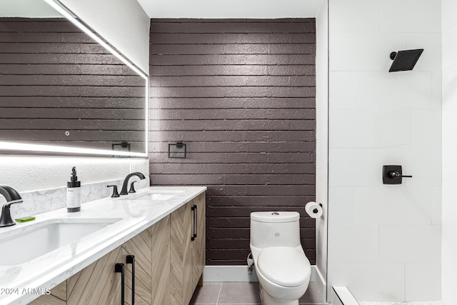 bathroom with a sink, toilet, double vanity, and tile patterned floors