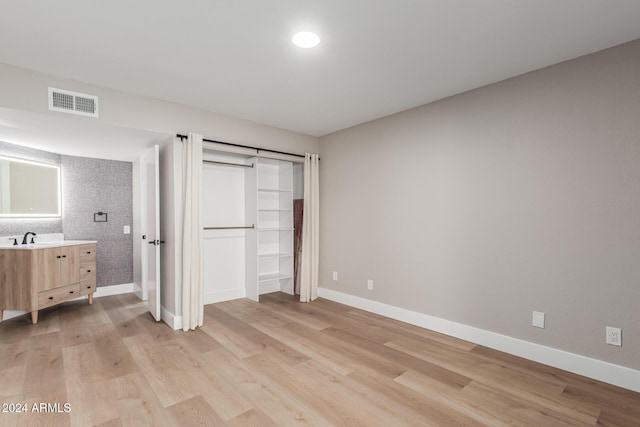 unfurnished bedroom with light wood-style floors, visible vents, and baseboards