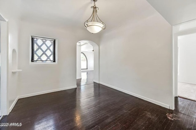 3949 E Earll Dr, Phoenix, AZ 85018 - unfurnished room with dark wood-style floors, arched walkways, and baseboards