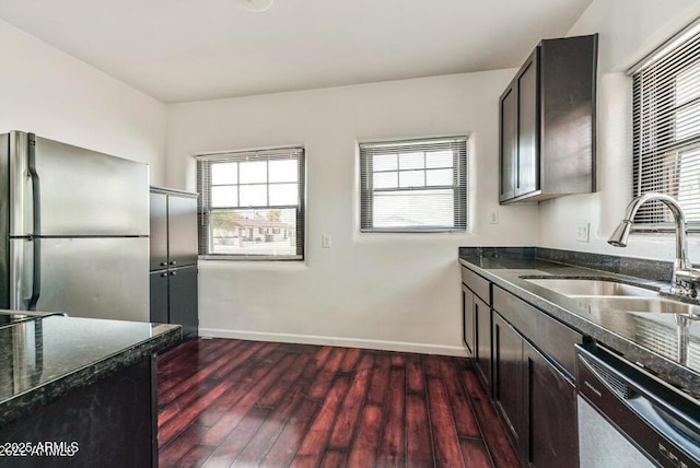 3949 E Earll Dr, Phoenix, AZ 85018 - kitchen featuring appliances with stainless steel finishes, a sink, baseboards, dark wood-type flooring, and dark stone counters