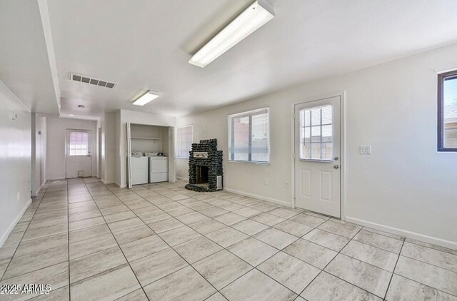 3949 E Earll Dr, Phoenix, AZ 85018 - unfurnished living room featuring light tile patterned floors, healthy amount of natural light, and washing machine and dryer