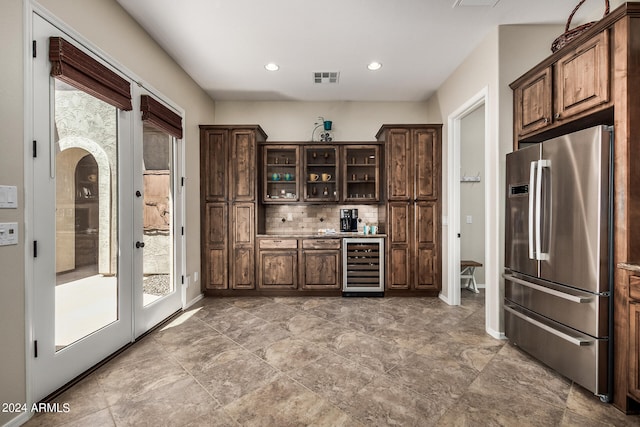 kitchen featuring stainless steel refrigerator, dark brown cabinets, wine cooler, and tasteful backsplash