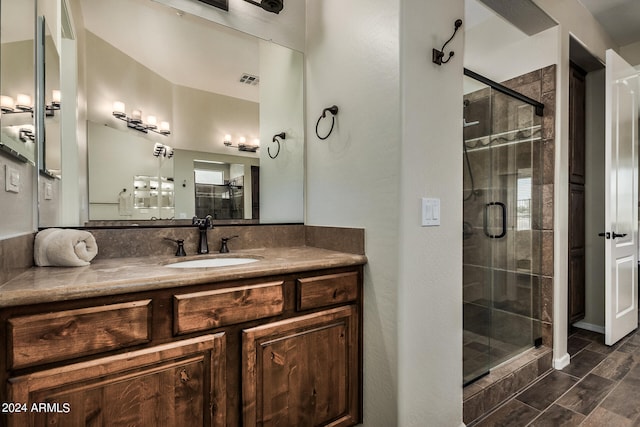 bathroom featuring a shower with door and vanity