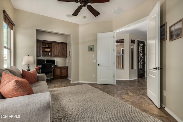 living room featuring ceiling fan and dark tile patterned floors