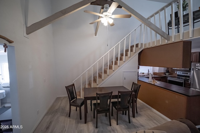 7411 N Toya Vista Rd, Payson, AZ 85541 - dining space featuring wood finished floors, a ceiling fan, a high ceiling, and stairs