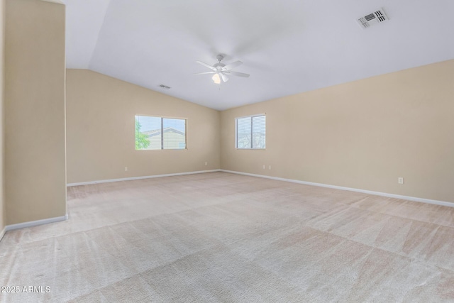 carpeted spare room with ceiling fan and vaulted ceiling