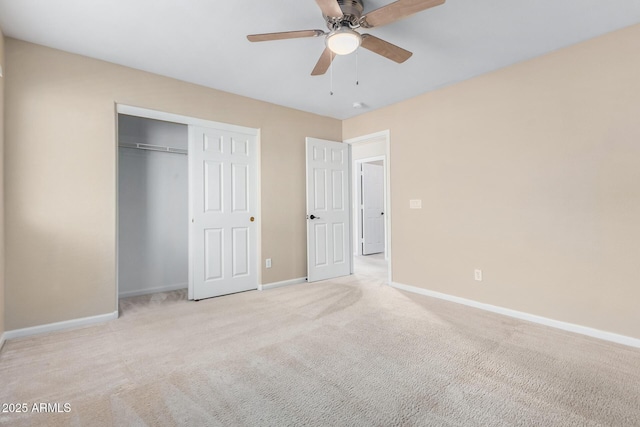 unfurnished bedroom featuring ceiling fan, a closet, and light carpet