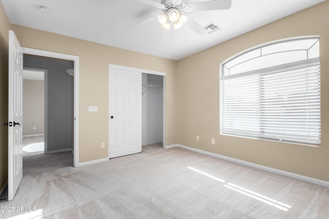 unfurnished bedroom featuring a closet, light carpet, and ceiling fan