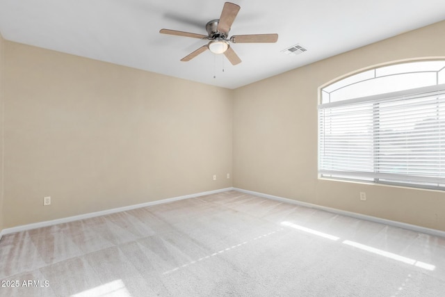 spare room featuring light carpet and ceiling fan