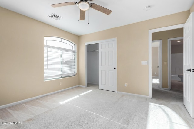 unfurnished bedroom with ceiling fan, light colored carpet, and a closet