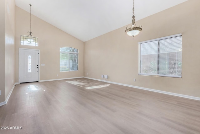 foyer with high vaulted ceiling and light wood-type flooring