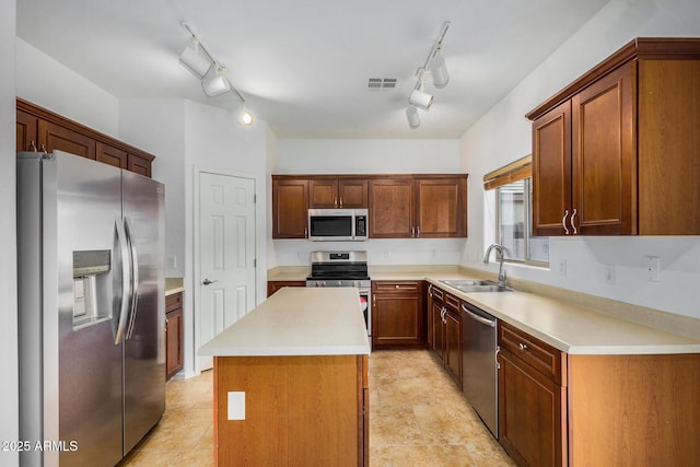 kitchen with stainless steel appliances, sink, and a kitchen island