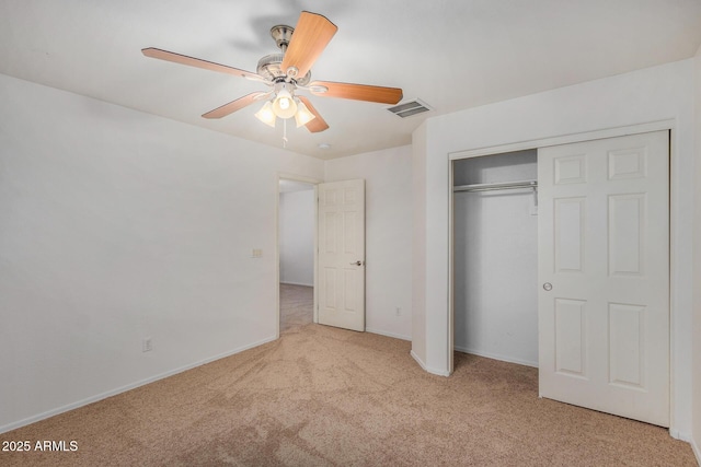 unfurnished bedroom with ceiling fan, light colored carpet, and a closet