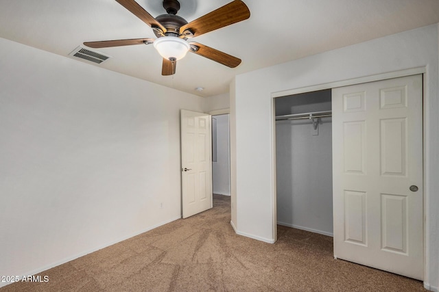 unfurnished bedroom with light carpet, ceiling fan, and a closet