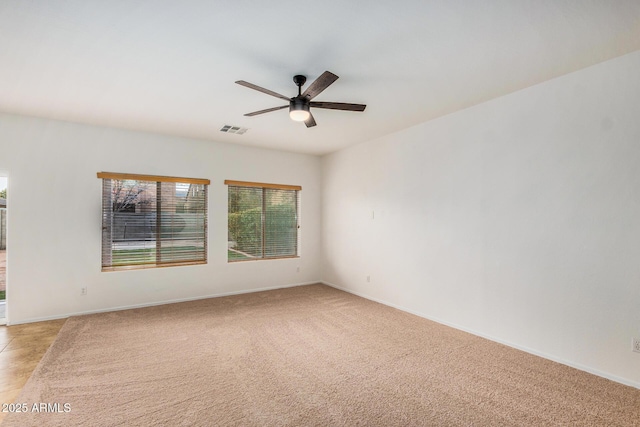 carpeted spare room with ceiling fan