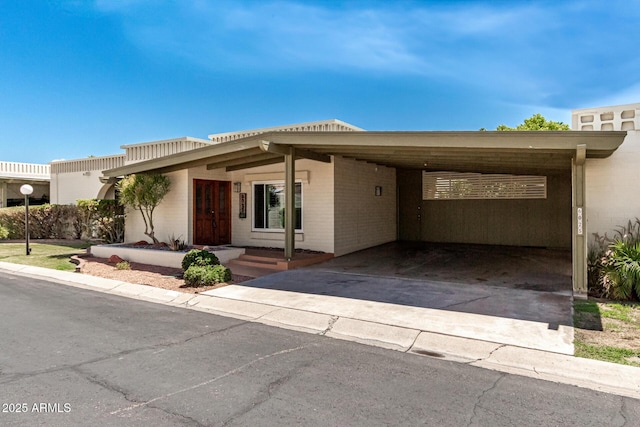 6025 N 10th Pl, Phoenix, AZ 85014 - view of front of property featuring brick siding, a carport, and driveway