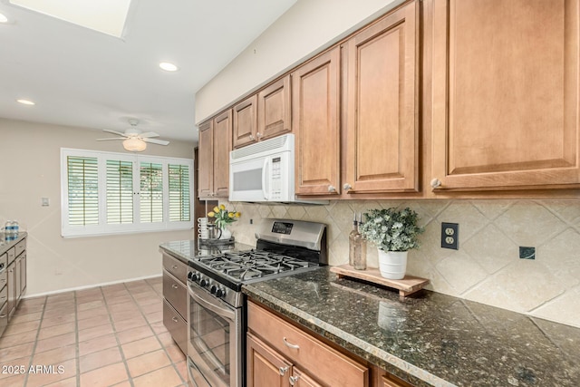 6025 N 10th Pl, Phoenix, AZ 85014 - kitchen with gas stove, white microwave, decorative backsplash, ceiling fan, and recessed lighting