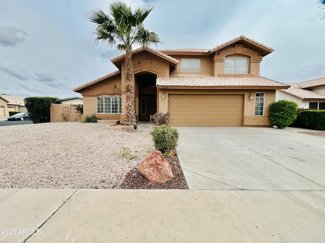 view of front of property with a tiled roof, stucco siding, driveway, and an attached garage