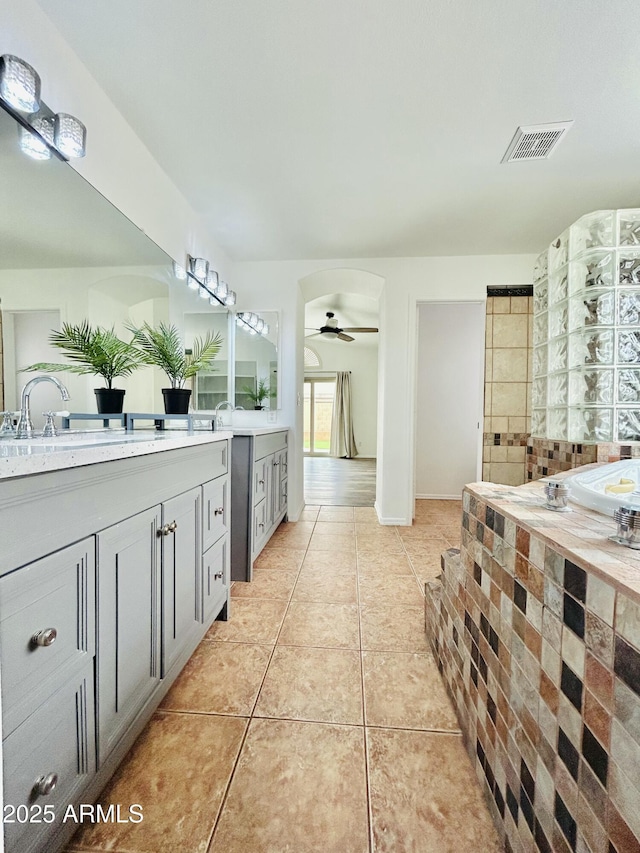 bathroom featuring tile patterned floors, visible vents, two vanities, a sink, and ceiling fan