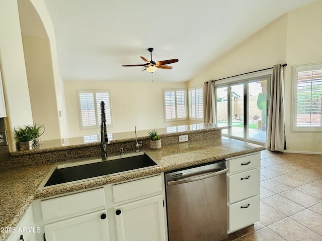 kitchen featuring light tile patterned floors, ceiling fan, a sink, vaulted ceiling, and dishwasher