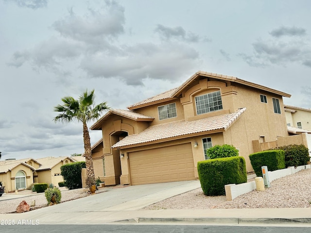 view of front of house featuring a tiled roof, stucco siding, driveway, and a garage