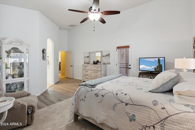 bedroom featuring light hardwood / wood-style flooring, high vaulted ceiling, and ceiling fan