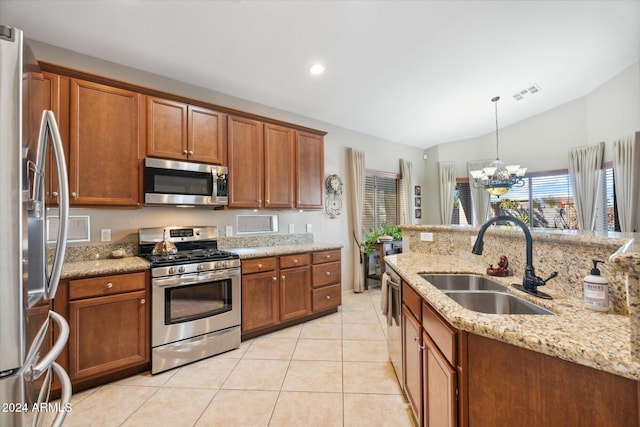 kitchen featuring sink, an inviting chandelier, pendant lighting, lofted ceiling, and appliances with stainless steel finishes