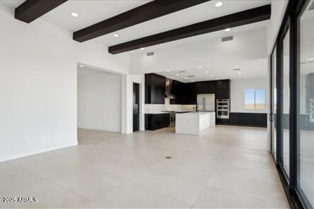 unfurnished living room with recessed lighting and beamed ceiling