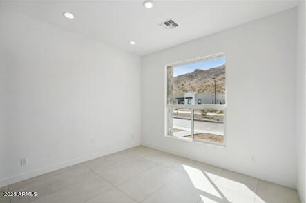 spare room with recessed lighting, visible vents, and baseboards