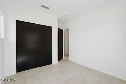 unfurnished bedroom with visible vents and a closet