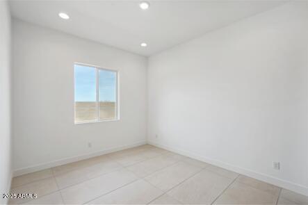 empty room featuring recessed lighting and baseboards