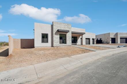 view of front of house featuring stucco siding, driveway, and a garage