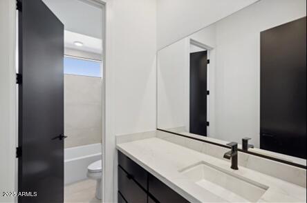 bathroom with vanity, toilet, and a bath