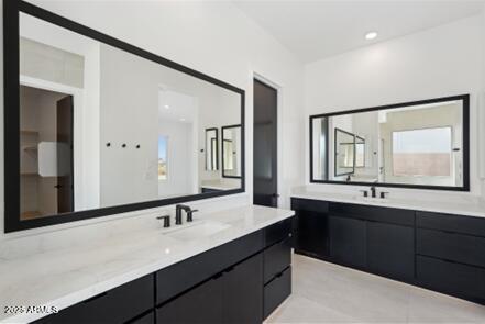 full bath with two vanities, recessed lighting, and a sink