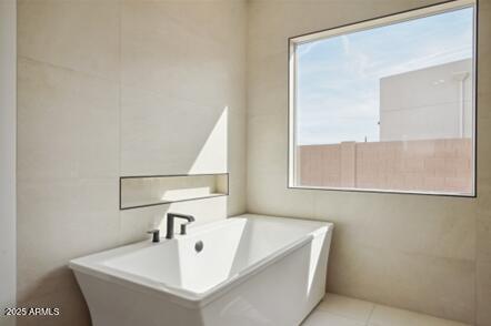 bathroom with tile patterned floors and tile walls