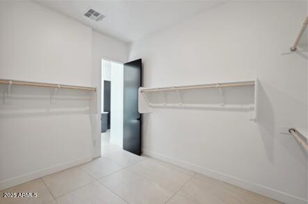 spacious closet with light tile patterned floors and visible vents