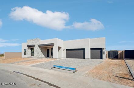 pueblo-style house with stucco siding and an attached garage